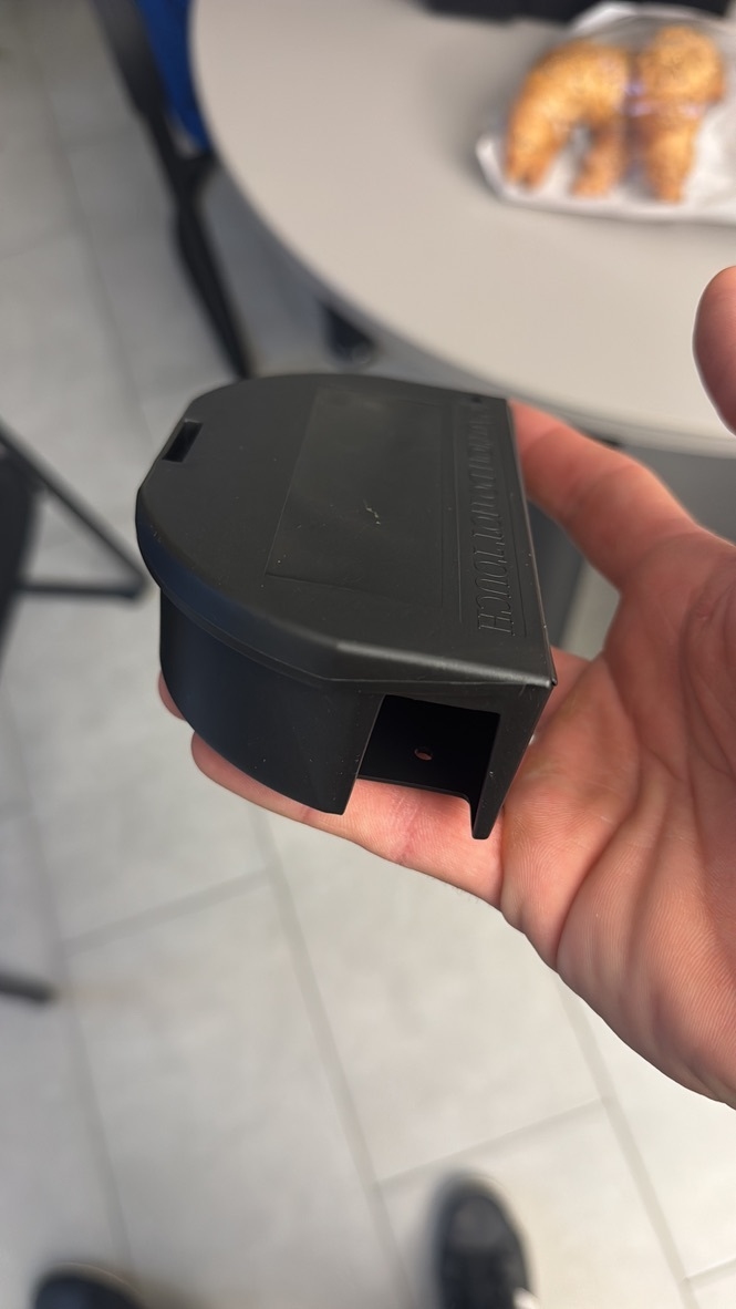 Ein Kammerjaeger haelt in Liedertswil eine kleine schwarze Kontrolleinheit in der Hand, waehrend im Hintergrund ein Tisch mit Gebaeck zu sehen ist.
