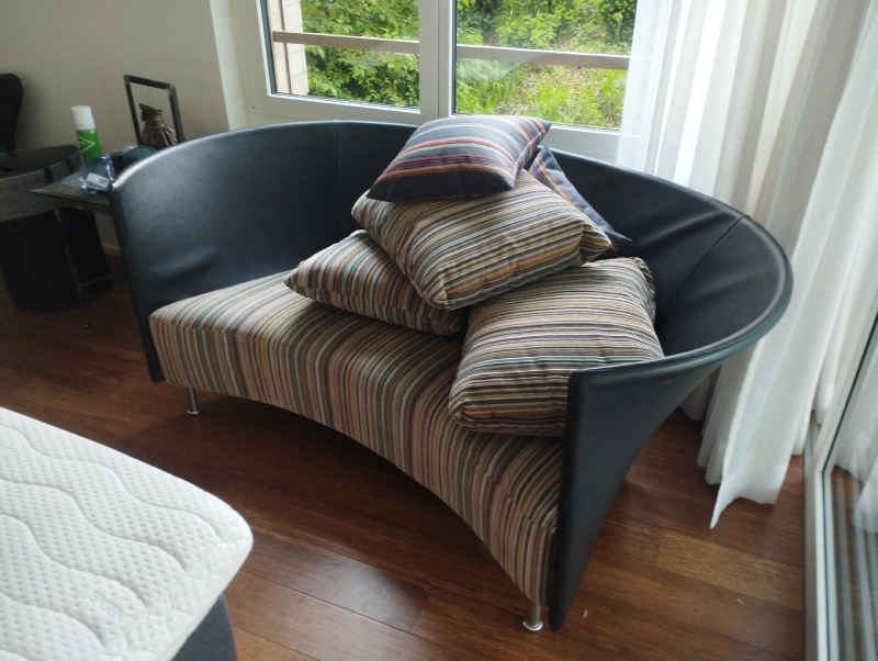 Ein Sofa in Wahlen, auf dem mehrere Kissen gestapelt sind. Bettwanzen können sich in diesen Bereichen verstecken. Es wird empfohlen, einen Kammerjäger zu rufen.